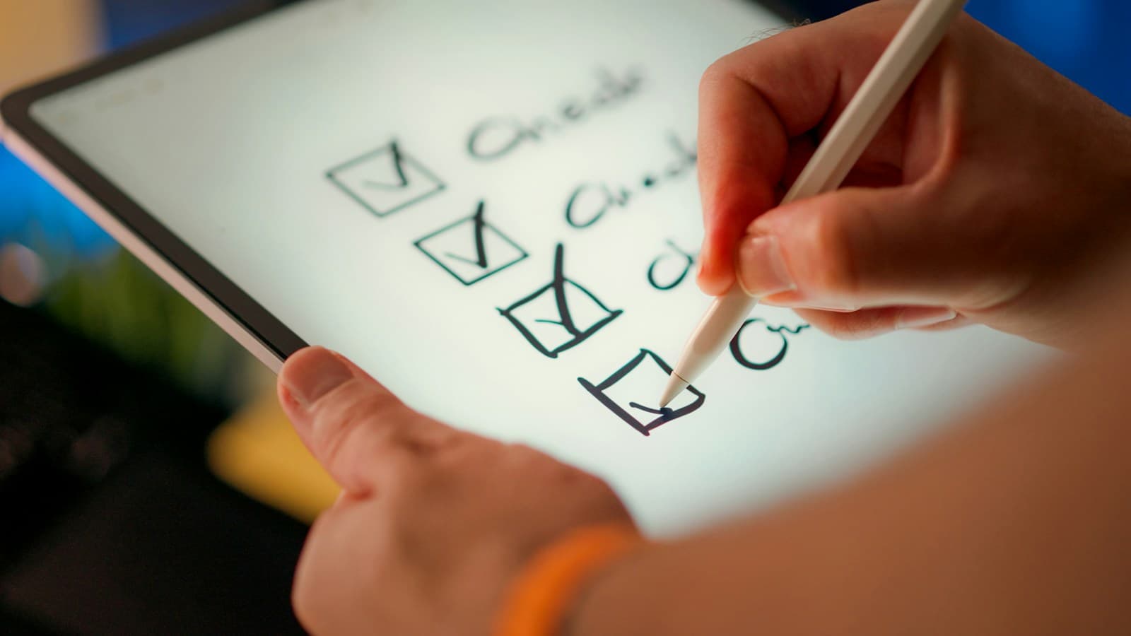 A hand ticking boxes on a handwritten checklist on a tablet with a stylus